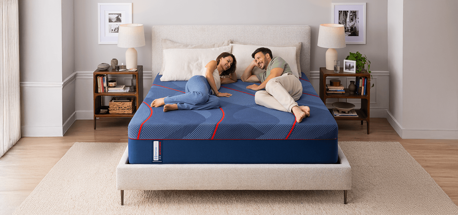 Couple laying on a Posturepedic Elite Hybrid mattress in styled room