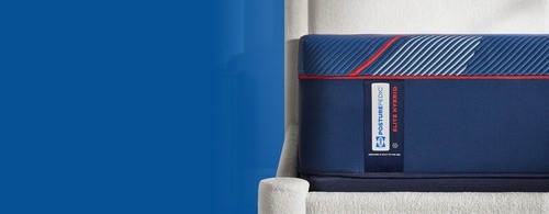 Side view of Posturepedic Elite hybrid mattress with blue background