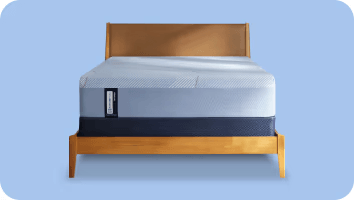 Posturepedic Hybrid mattress on a foundation with a blue background