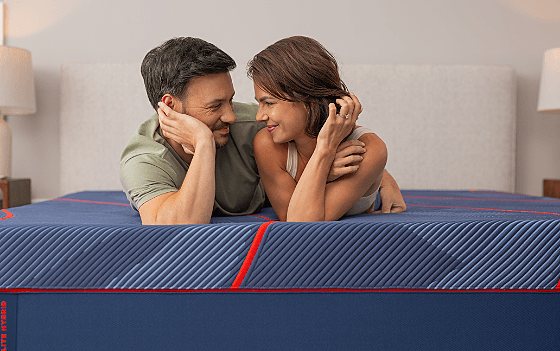 A couple laying on a Posturepedic Elite Hybrid mattress